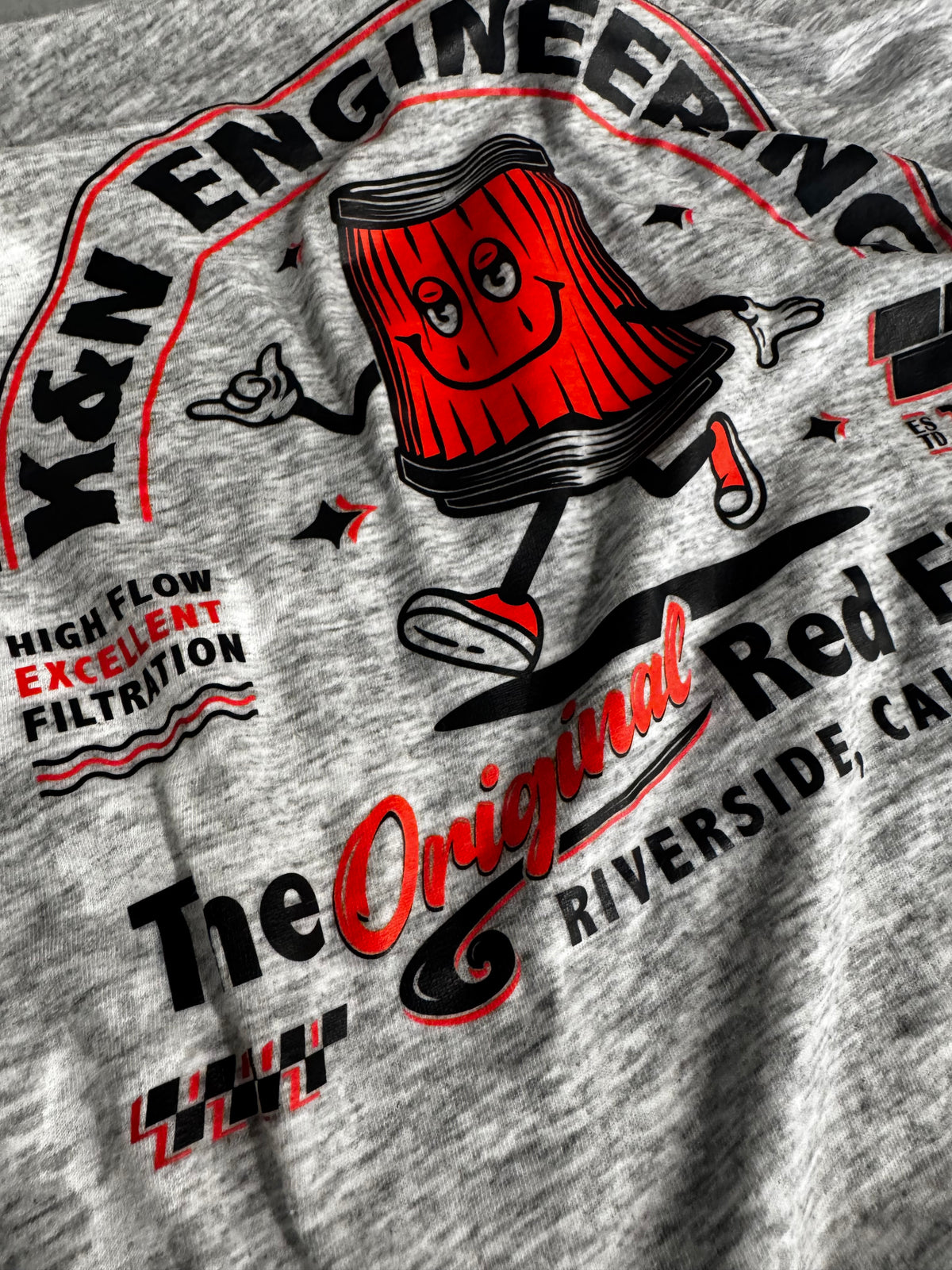 Close-up of a durable red, black and white DTF transfer applied to a heather-gray shirt.
